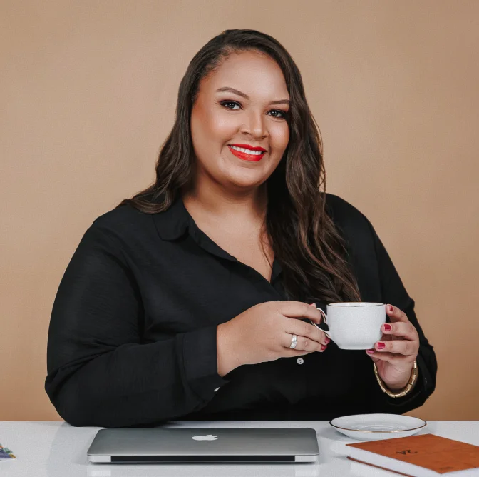 Advogada Patrícia de Jesus tomando café à mesa do escritório com notebook e agenda, em atendimento jurídico acolhedor e especializado